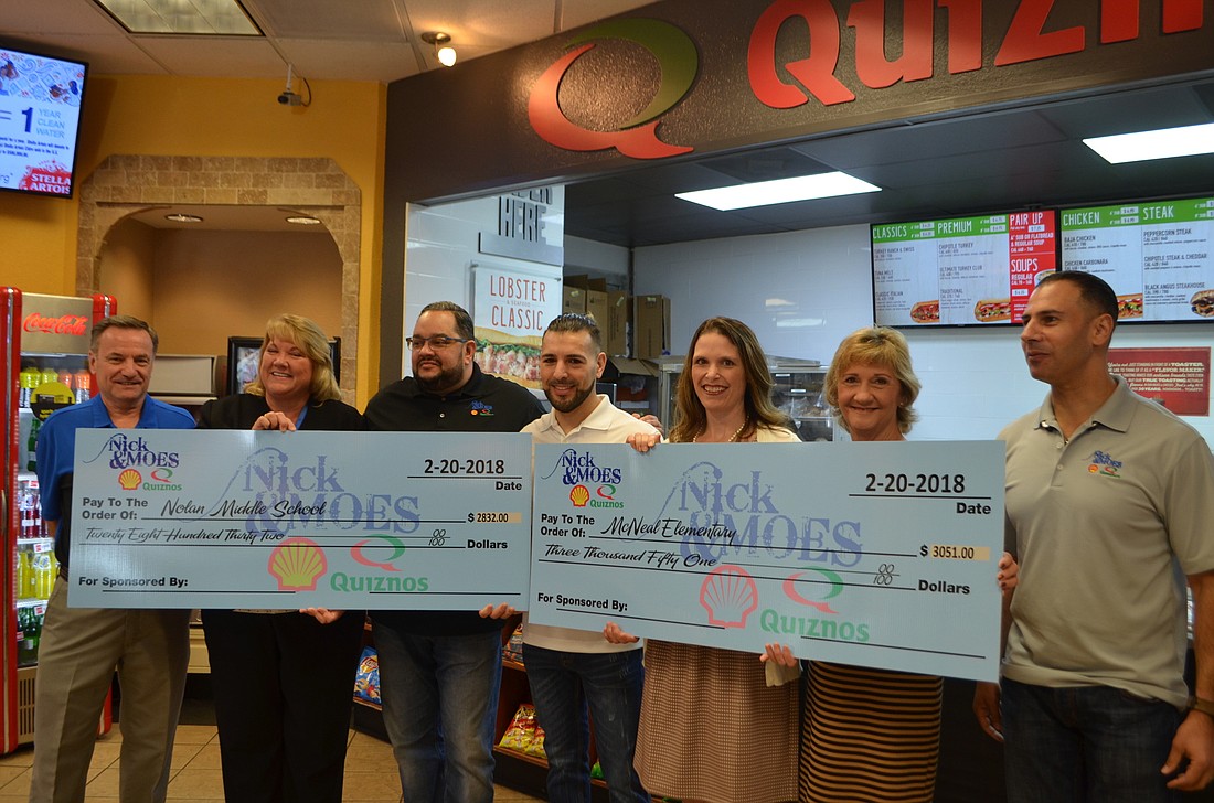 Art Vetter from J.H. Williams Oil Company, Nolan asst. principal Lori Jones, owners Jose Rodriguez and Mike Hass, McNeal asst. principal Carol Ricks, County Commissioner Vanessa Baugh and owner Nick Salen  presenting the checks.