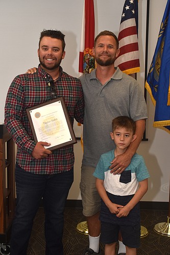 Taylor Rahn poses with his award and Steven and Simeon Brubacher, two of the five people he rescued.
