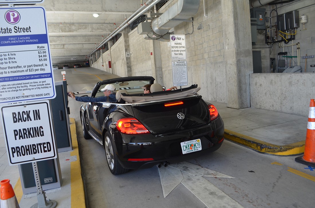 A visitor to the State Street parking garage grabs a ticket Feb. 17 from the newly installed paid parking machines.