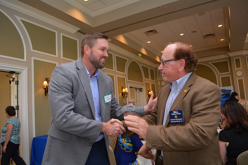 Premier Community Bank's Chris Perkins hugs his old friend and Rotarian Bill Porter.
