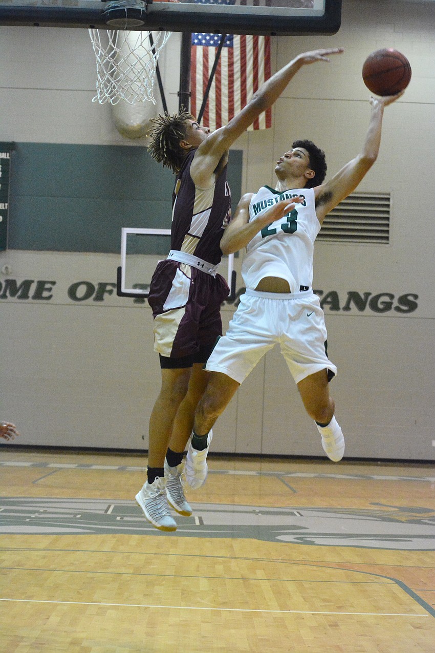 Sophomore Christian Shaneyfelt throws up a shot over a Riverdale defender in mid-air.