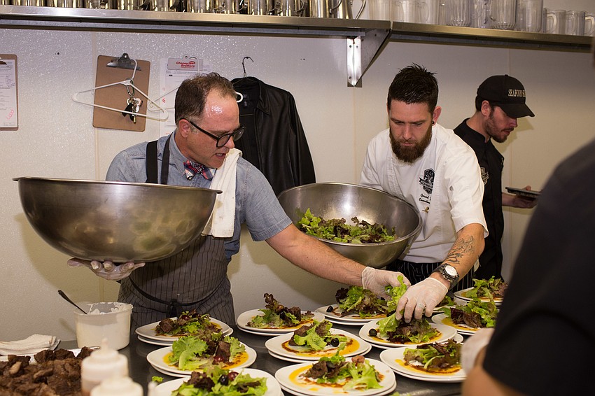 Chef Chair Christian Hershman lays the salad on his dish, featuring local greens and braised beef rib meat.