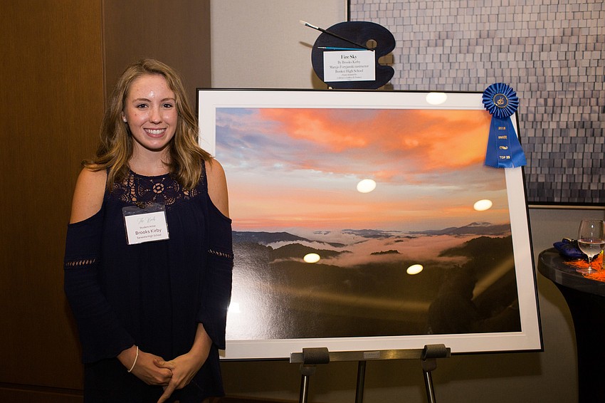 Brooks Kirby stands next to her artwork, 