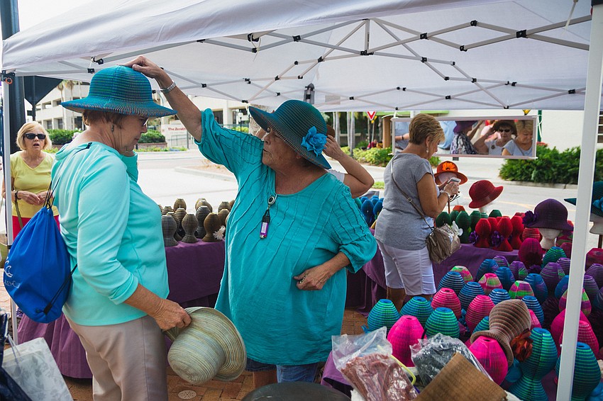 Ginny Waldheim places one of her Ya-Ya Hats on a customer.