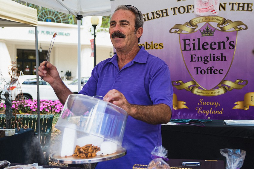 Phillip Bauman theatrically offers samples of Eileen's English Toffee to market shoppers.