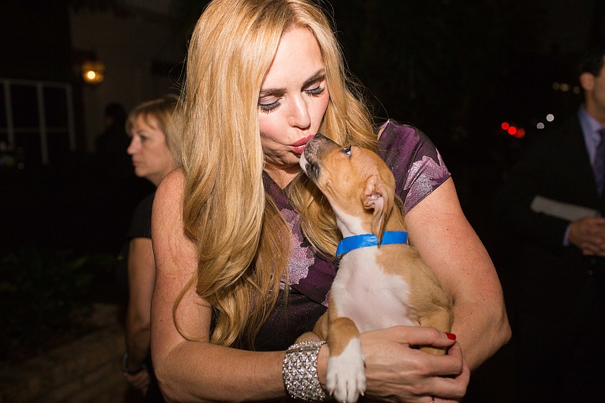 Co-Chairwoman Melissa Howard gives kisses to Wrigley.