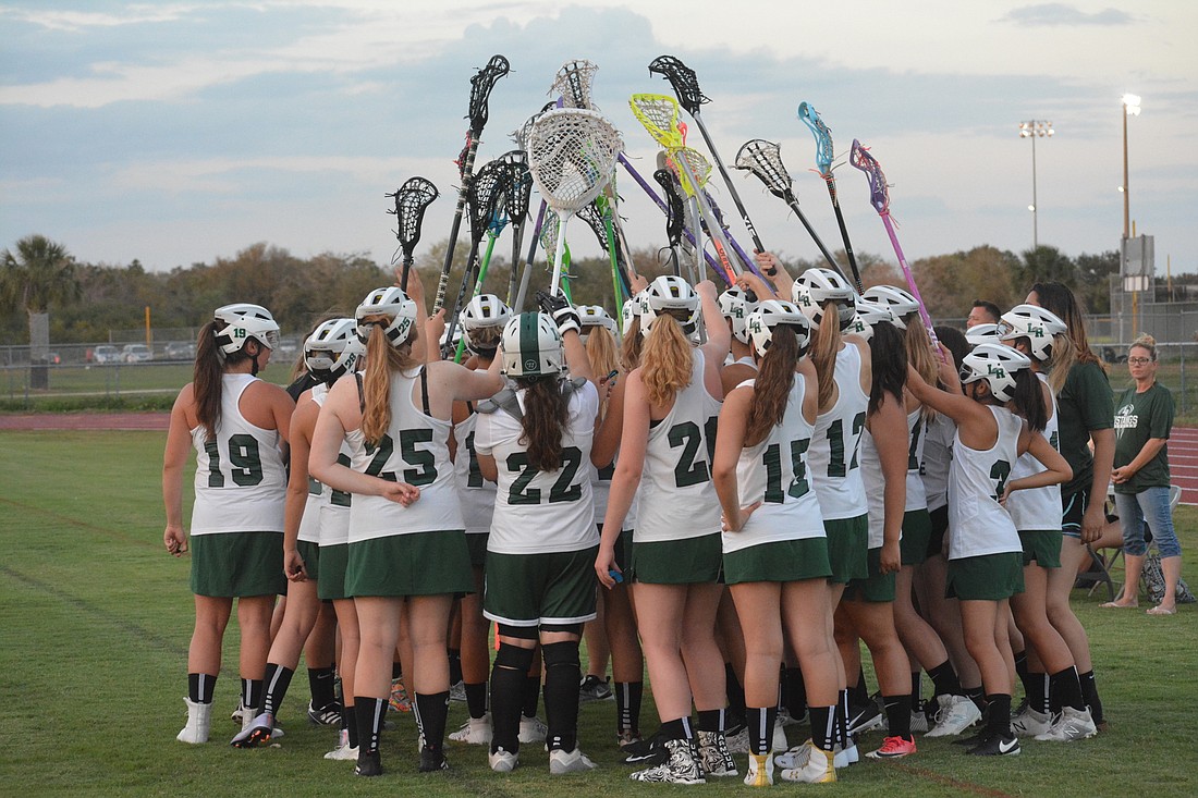 The Lakewood Ranch girls lacrosse team huddles prior to its first-ever game.