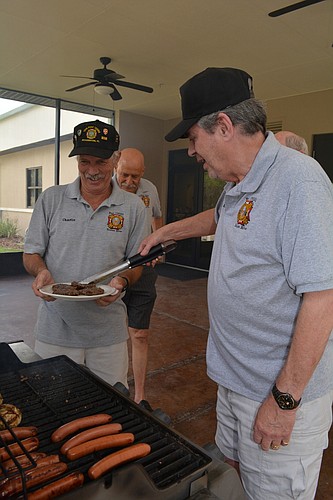 VFW Post 12055 Chaplain Ernie Freedman serves up hot dogs to fellow post member Charlie Busack.