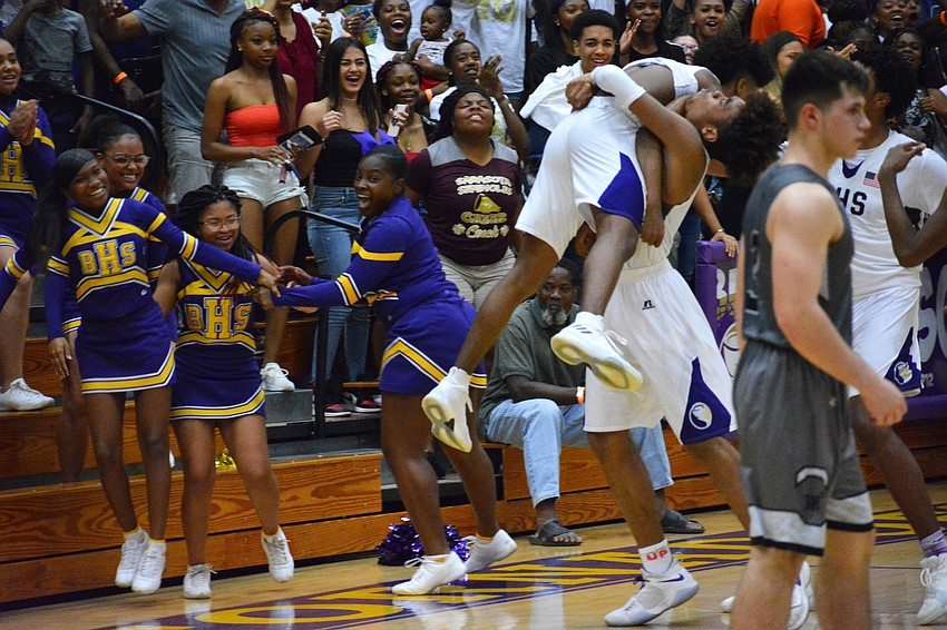 Jaylen Jones is hoisted into the air by Johnnie Williams IV.