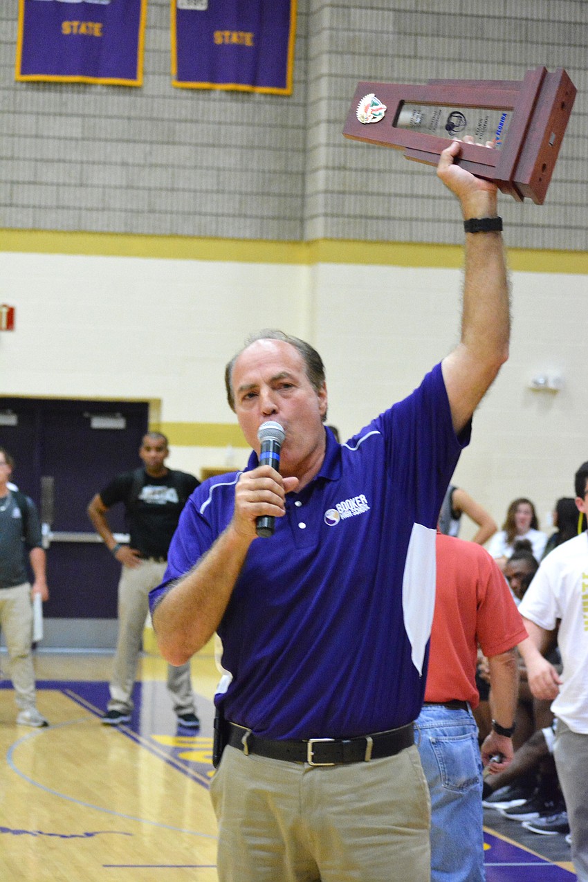 Booker athletic director Phil Helmuth raises the Class 6A regional trophy.