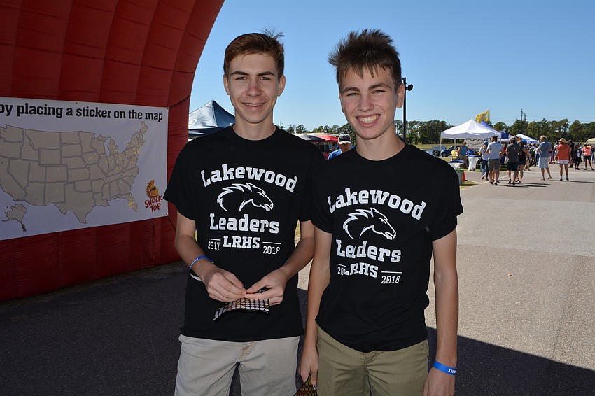 Lakewood Ranch High School freshmen James Archibald and Reid Zimmerman  pass out stickers so people can mark their hometowns on a giant map.