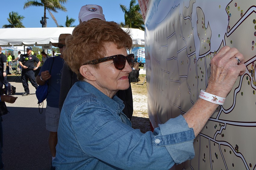 Lois Thompson and her husband, Jim, not pictured,  mark their hometown of Pittsburgh on a giant map as they enter the festival.