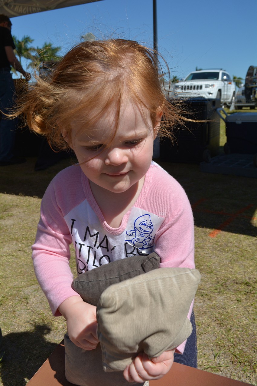 Mill Creek's Avery DeLosh, 19 months, skipped nap time for a game of corn hole.