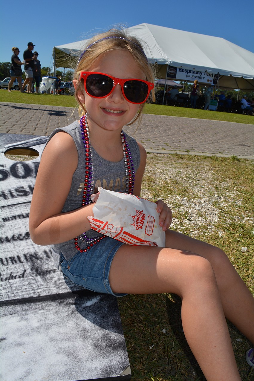 Sarasota's Marin Lank, 4, munches on popcorn from the Observer Media Group booth.