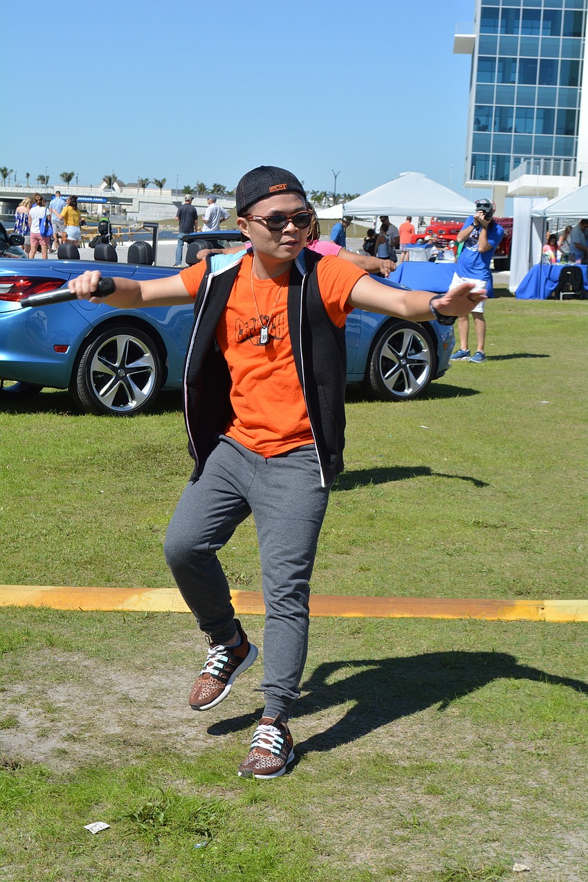 Crunch Fitness instructor Dat Vu leads a zumba lesson while a band gets set up.