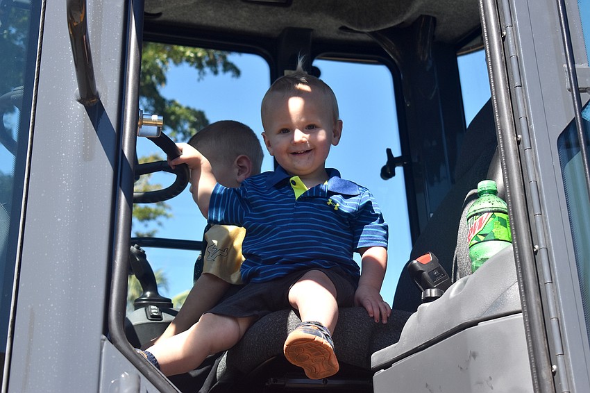 Grayson Adams smiles as he tests out a tractor at the open house.