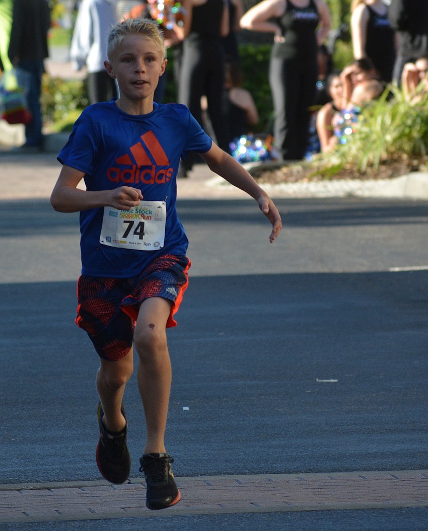 Summerfield's Jonathan Leatt, an 11-year-old McNeal student, soars above the ground as he wins the overall 5K race in 18:28.