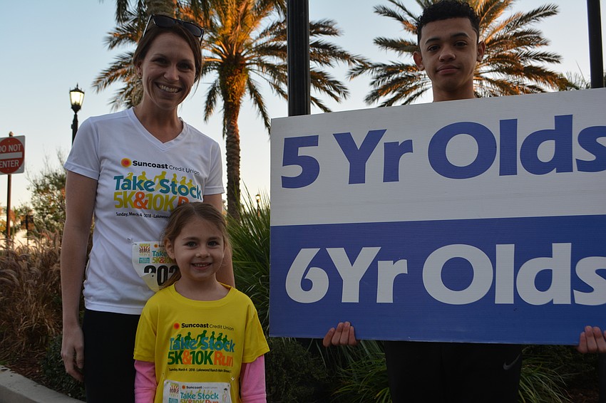 Parrish's Reese Phillips, 5, finds the right starting line with help from mom, Kristen Phillips, and volunteer Eriel Crispin.