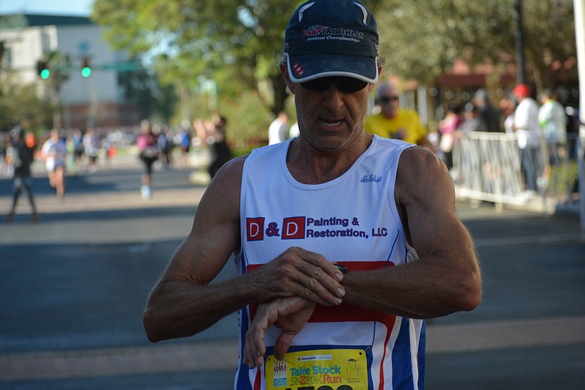 Sarasota's Andrew Swanson checks his time after finishing the 10K.