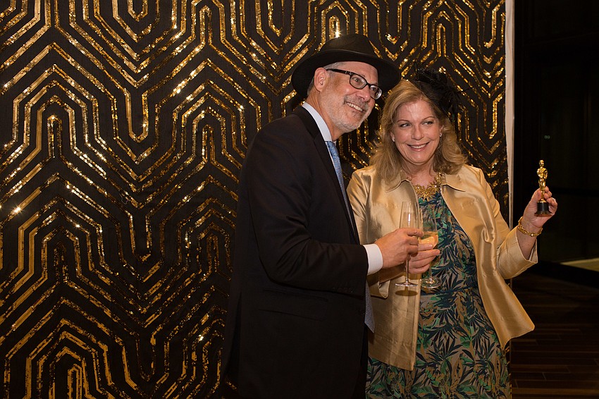 Lew and Kathy Sandy hold up a mini Oscar trophy in the photo booth.