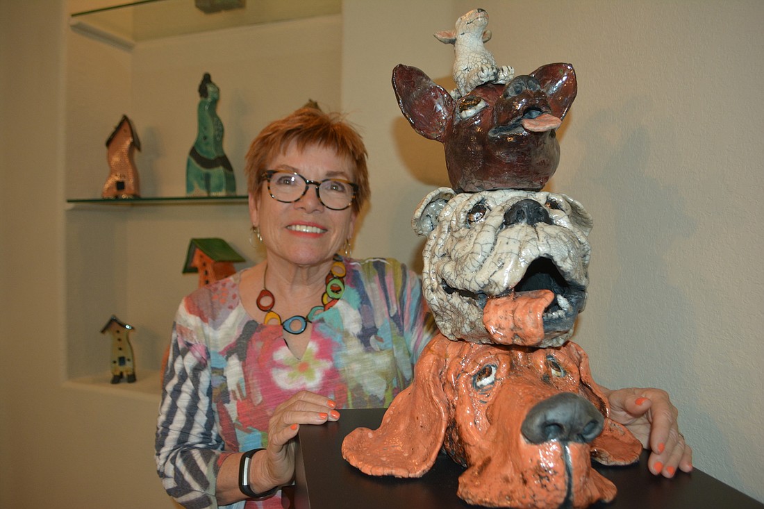 Sue Kerr shows off a totem project featuring dogs.