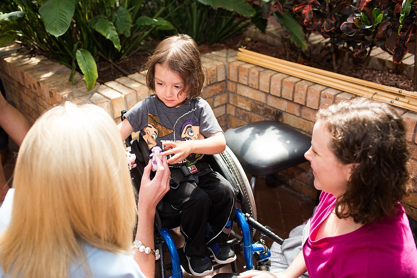 Britt Riner plays with toy cows with Damon and Hannah Warne.