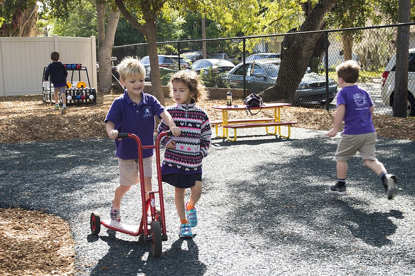 Anderson Miller, left, scoots along the playground with a new friend from Children First.