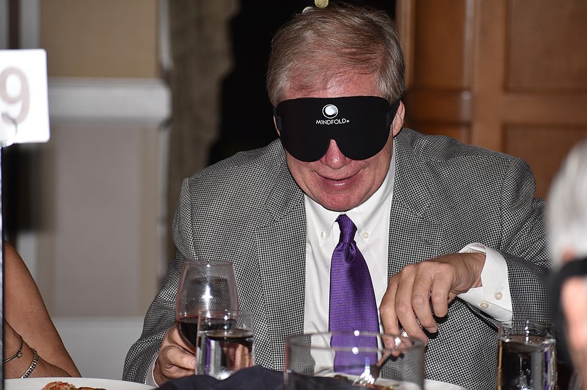 Steve Carlson attempts to eat his dinner with a blindfold on.