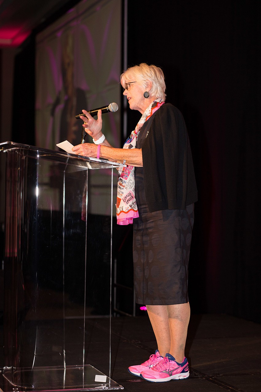 Co-Chairwoman Clare Segall introduces keynote speaker Wendy Davis, while wearing the same brand of pink sneakers Davis wore.