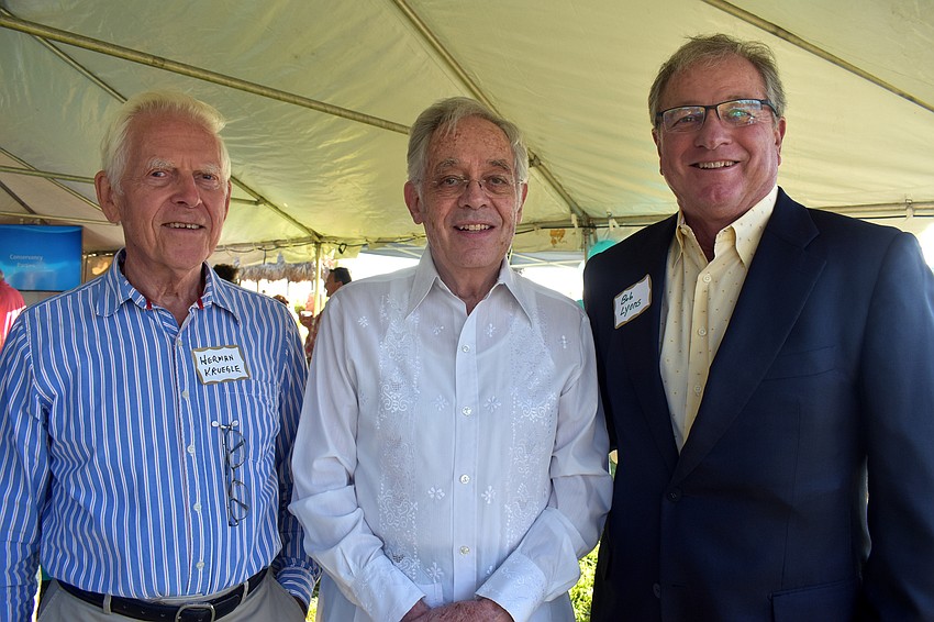 Anniversary committee members Herman Kruegle and Denton Crews and Whitney Beach Condominium Association President Bob Lyons