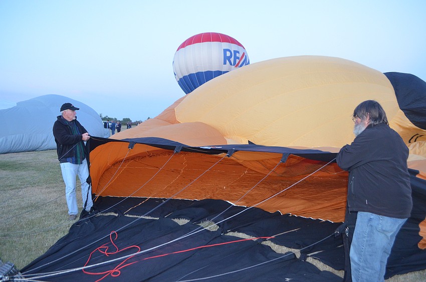 Volunteers Chuck Ness, visiting from San Antonio, and Mike Koepfle, from Lakeland, assist while a hot air balloon inflates.