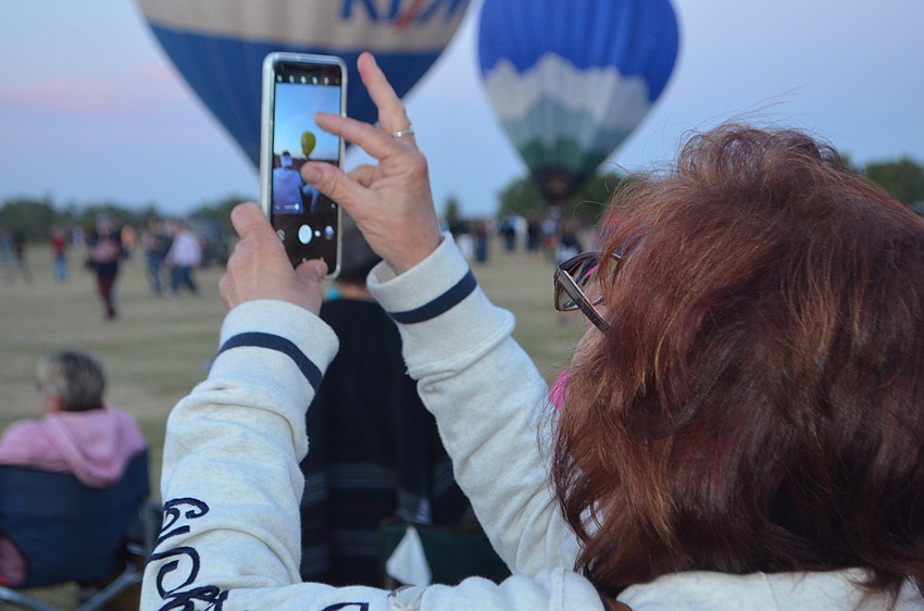 Siesta Key's Ginny Nese takes a photo as a balloon takes off.