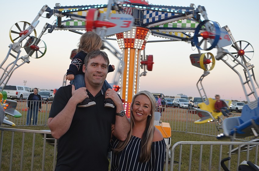 Sarasota's Tom Harrison, and Laura Purcell stand in front of a ride that captures the interest of their son, Harrison.