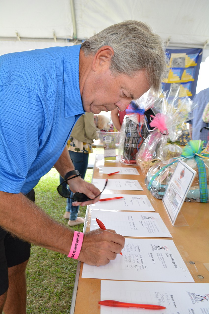 Sarasota's Mike Roberts bids on a golf foursome during the silent auction.