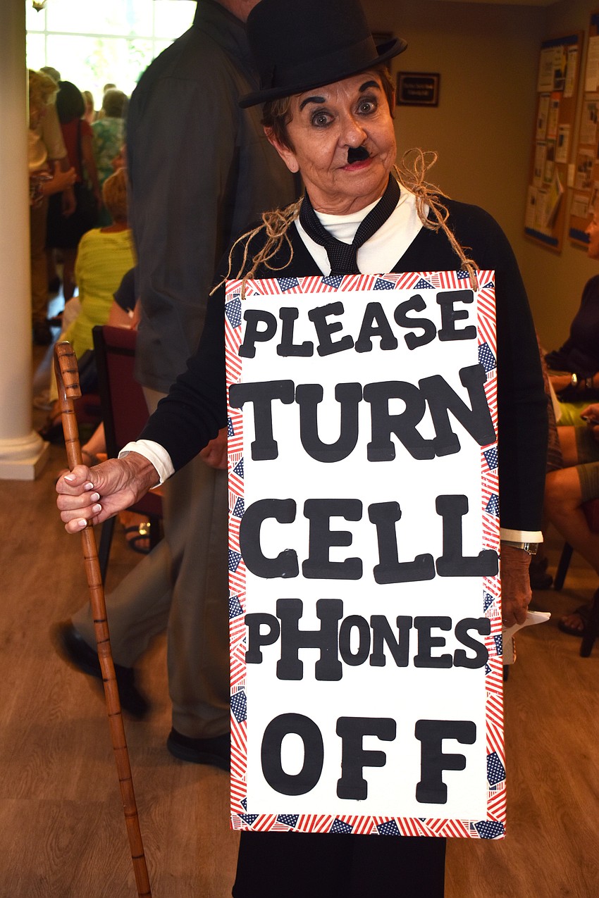 Carol Peschel acts as Charlie Chaplin and advises the audience to turn off their cell phones.