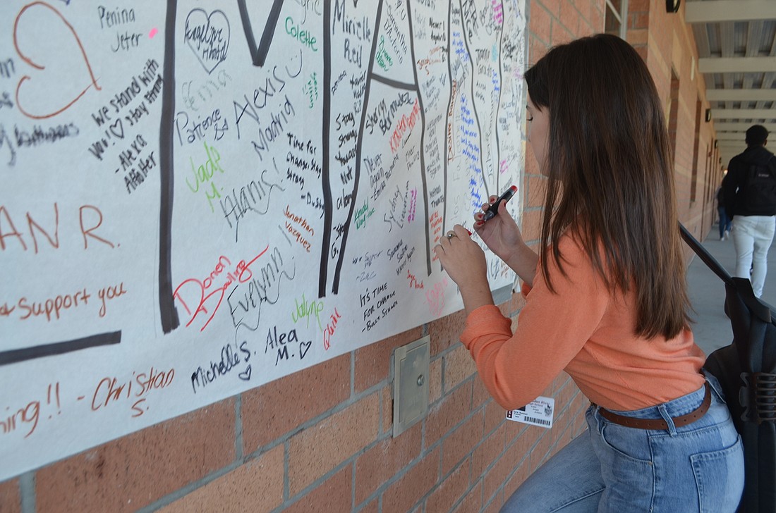 Sara Nussar, a freshman at Braden River High School, signs her name before she has to go back to class.