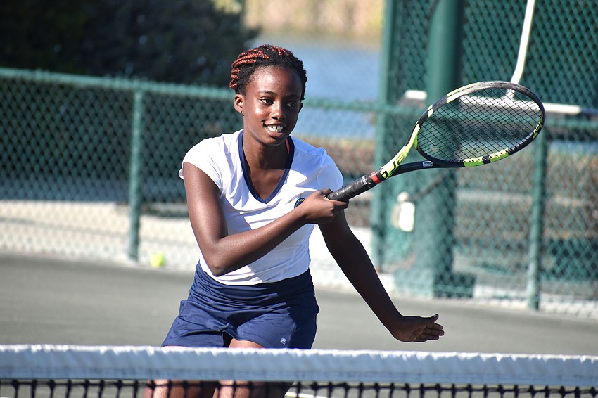 Athlete Jennifer Ibeto swings during a tennis drill during the exhibition.