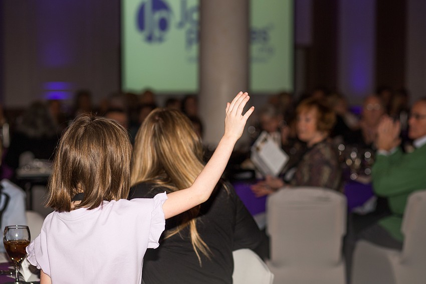 Charlotte Twigg, who has been helped by JoshProvides, raises her hand as she is recognized.