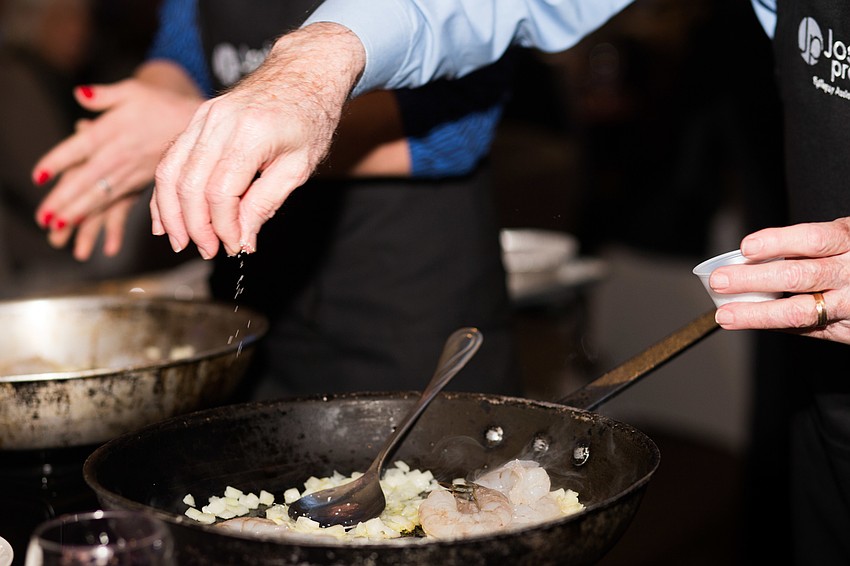 Mike Foreman sprinkles garlic into the dish.