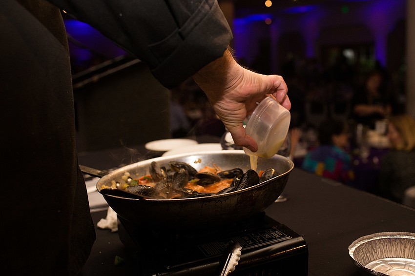 Michael's On East Chef Jamil Pineda pours the final ingredient into the pan.