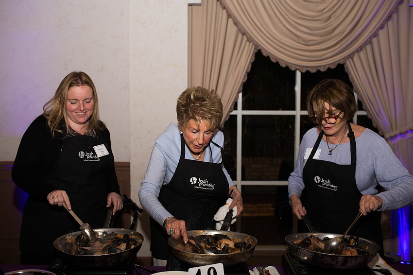 Amanda Twigg, Renee Sheade and Jane Conner cook the first course, a Cuban seafood sofrito.