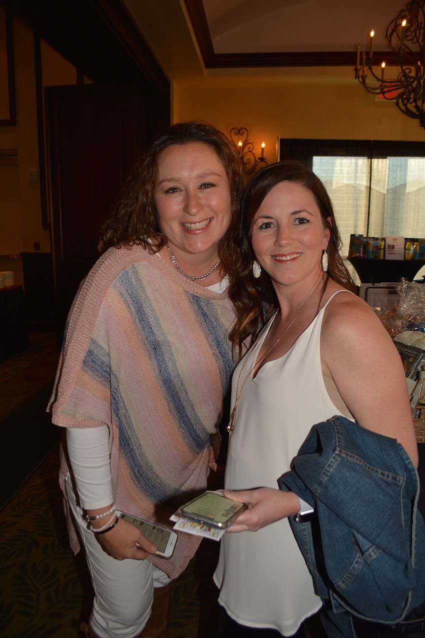 Elizabeth Besterman and Jennifer Danahy have their eyes on a specific silent auction item — a Greek dinner for six cooked by Willis counselor Phyllis Morales.