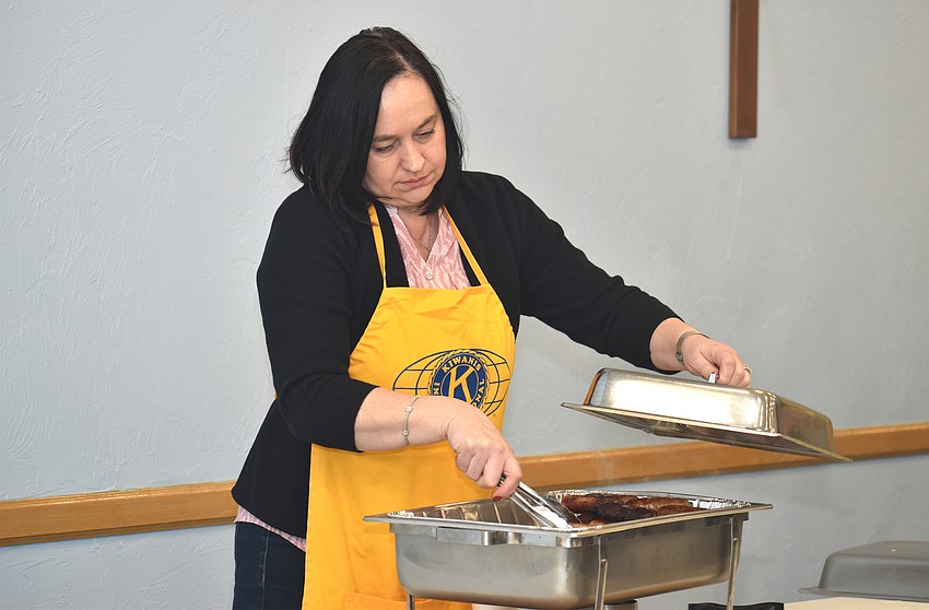 Asima Palmer serves sausage during the breakfast.