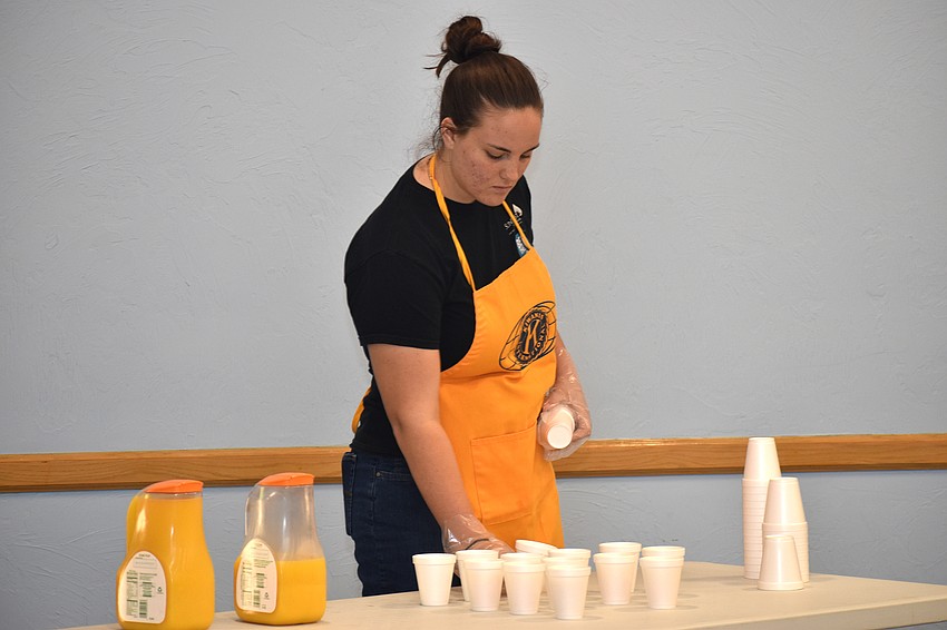 Sune Venter prepares cups of orange juice for attendees.