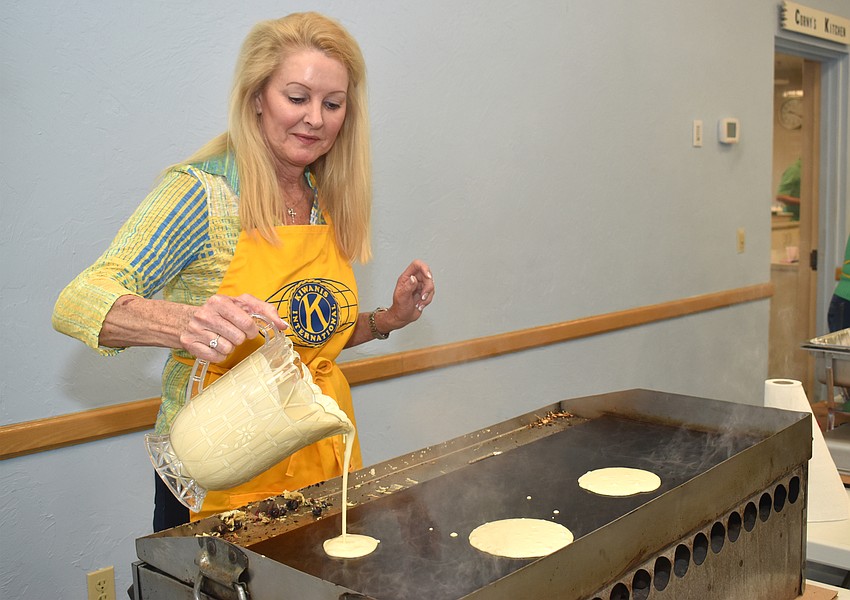 Susan Phillips pours batter to make a batch of pancakes.