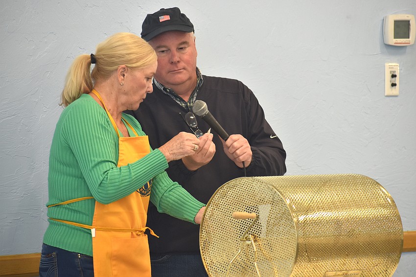 Phyllis Black and Jack Brill call the raffle ticket number for the first 50/50 drawing.