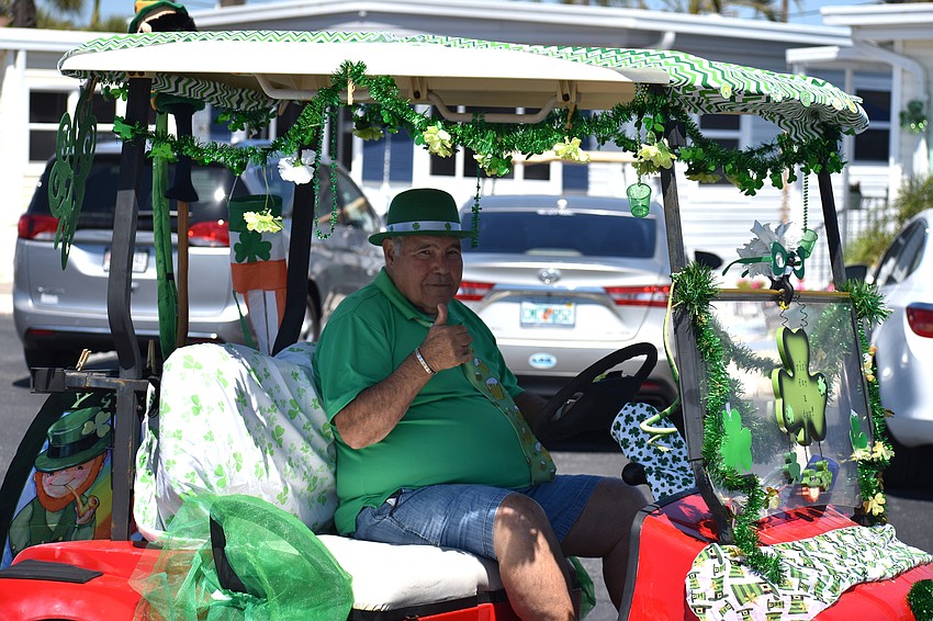 Joe Zampino gives a thumbs up as he rides his golf cart through the parade route.