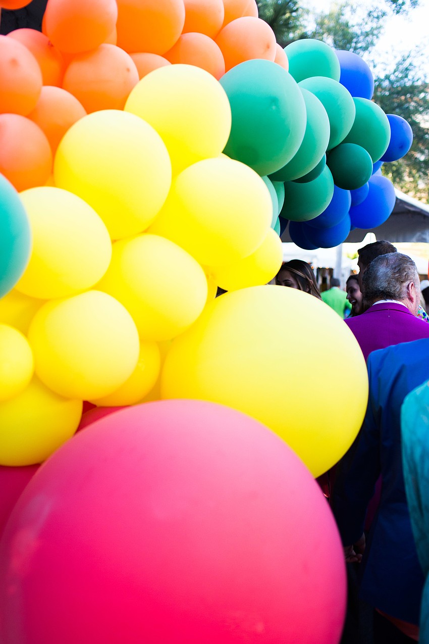 Colorful balloons popped against the white tent background.