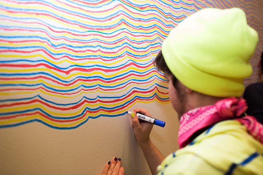 Jayden Irizarry draws on the wall as part of Sol LeWitt: 