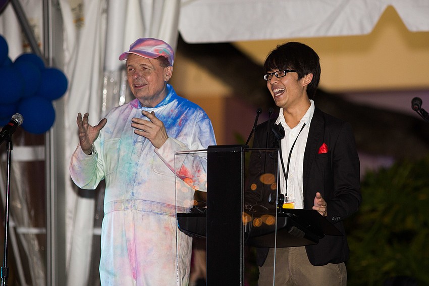 Ringling College President Larry Thompson and scholarship recipient Dionisius Bangun laugh together on stage.